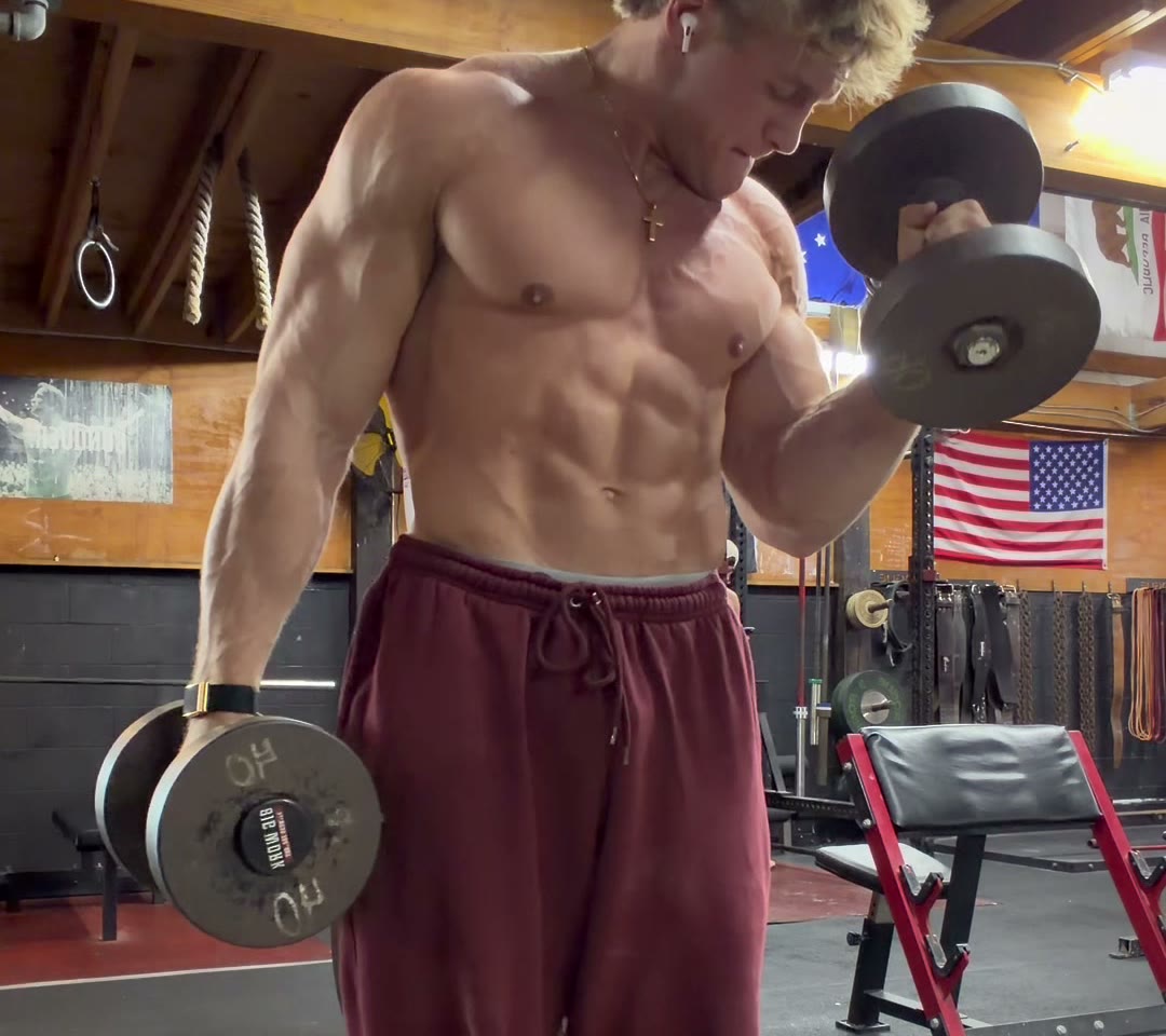 Cole mid-curl with a dumbbell in the gym